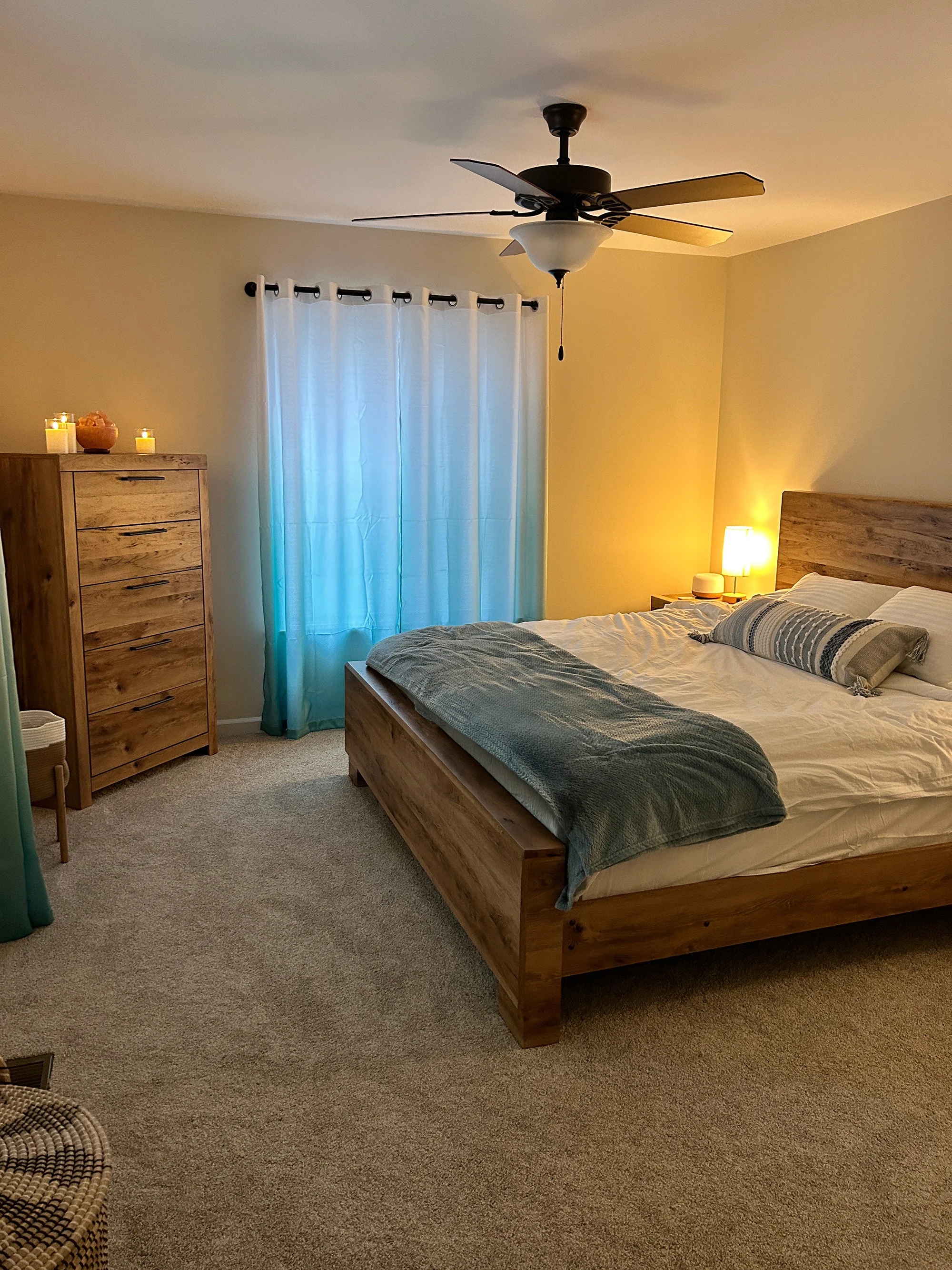 A calm guest bedroom with warm wood furniture and soft lighting